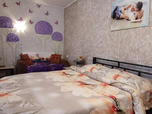 ein Schlafzimmer mit einem großen Bett mit einem Bild an der Wand in der Unterkunft Apartment on Sobornaya 58 in Chmelnyzkyj