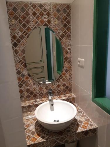 a bathroom with a sink and a mirror at Rumah Jawa Guest House (Syariah) in Yogyakarta