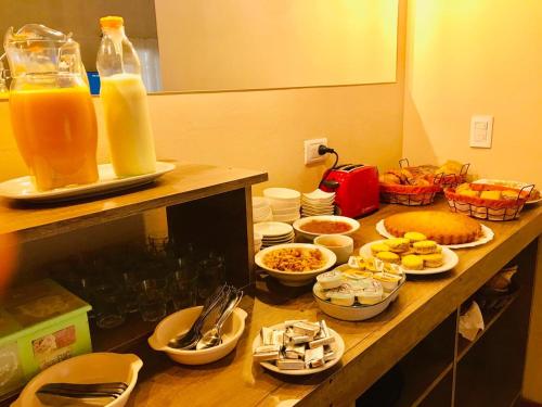 een tafel met borden en flessen sinaasappelsap bij Cortaderas Hotel de Campo Nono in Nono