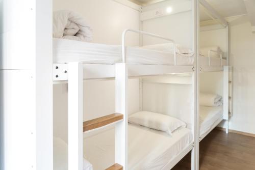 a room with white bunk beds in it at Pars Teatro Hostel in Barcelona