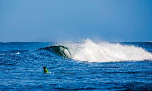a person riding a wave on a surfboard in the ocean at Tapas & Surf in Petacaltepe
