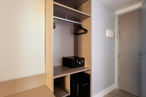a walk in closet with a black microwave in it at Flix Hotel in Maceió