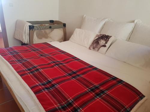 a dog laying on a bed with a red blanket at Arrayanes Royal in Sierra Nevada