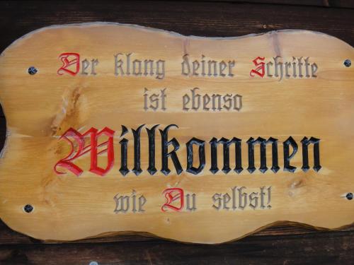 a wooden sign with writing on it on a table at Lehmann's Herberge Hostel in Grindelwald