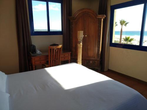 a bedroom with a bed and a view of the ocean at Beach Hotel Dos Mares in Tarifa