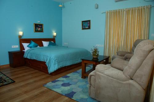 a bedroom with a bed and a couch and a chair at Zenha Resorts in Munnar