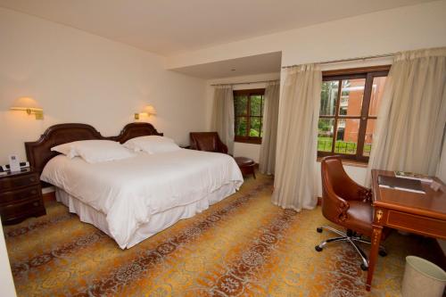 a hotel room with a bed and a desk and a desk at Barradas Parque Hotel & Spa in Punta del Este