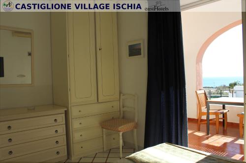 a bedroom with a dresser and a chestoireoire village ishtar at Hotel Castiglione in Ischia