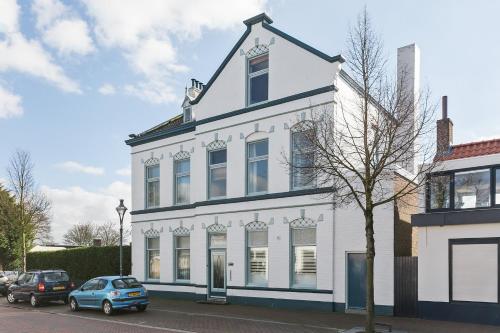 a white building with cars parked in front of it at B&B Papillon in Oost-Souburg