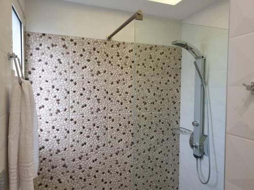 een badkamer met een douche met een douchegordijn bij Sea Breeze Villa in Charaki