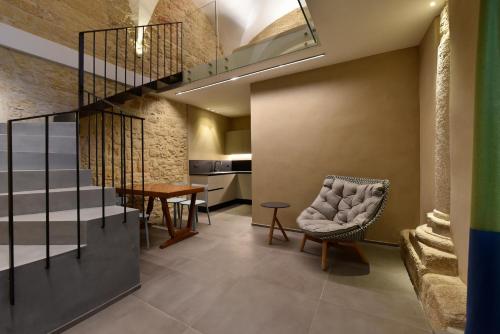 een kamer met een trap, een stoel en een tafel bij Chiostro di S. Antonio in Marsala