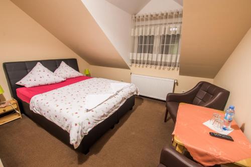 a small bedroom with a bed and a chair at Dwór Skalny Apartamenty, Pokoje i Restauracja Karczma Skalna in Miłków
