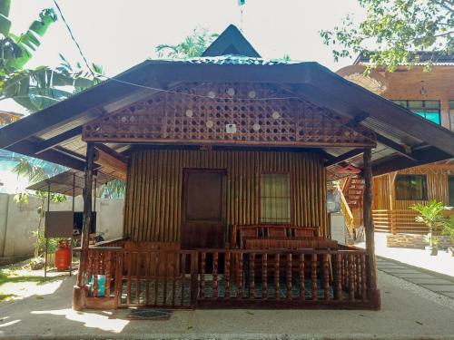 a small house with a roof with benches in front at Pitaya Native Guest House in Panglao