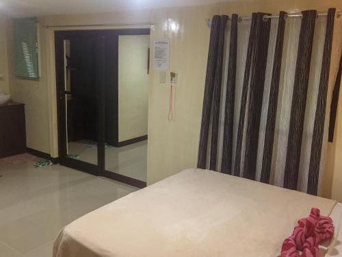 a bedroom with a bed and a door to a bathroom at Pitaya Native Guest House in Panglao