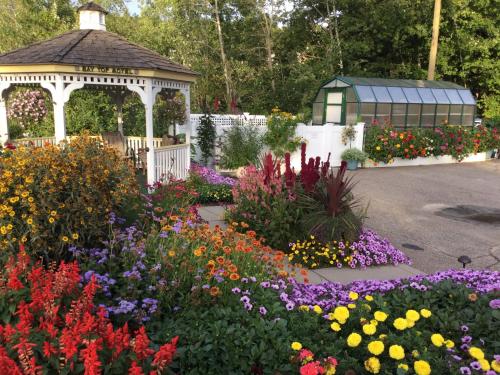 a garden with a gazebo and flowers at Bay Top Motel in Weirs Beach