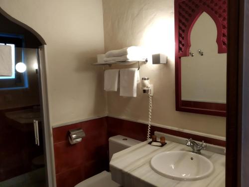 a bathroom with a sink and a toilet and a mirror at Beach Hotel Dos Mares in Tarifa