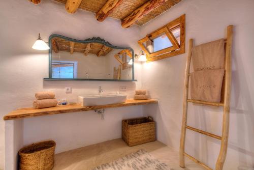 a bathroom with a sink, mirror and a tv at Can Quince de Balafia - Turismo de Interior in Sant Llorenç de Balafia
