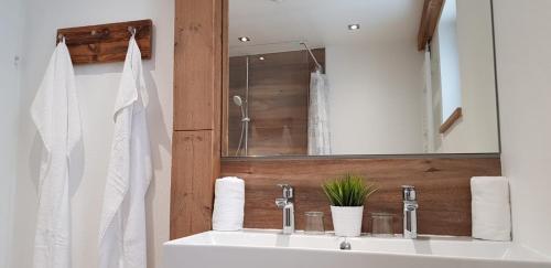ein Badezimmer mit einem weißen Waschbecken und einem Spiegel in der Unterkunft Haus Rosi in Uttendorf