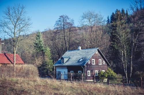 ein Haus mit blauem Dach auf einem Hügel in der Unterkunft Chalupa Rozmarýna in Mařenice