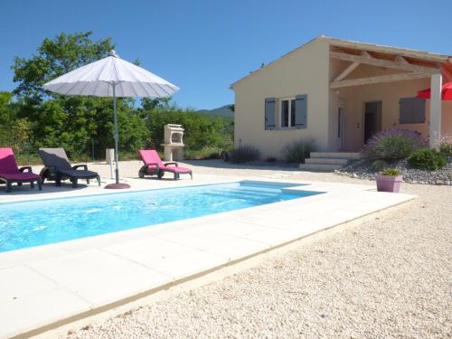 a pool with chairs and an umbrella next to a house at LES HAUTS DE JALLIA in Sainte-Jalle