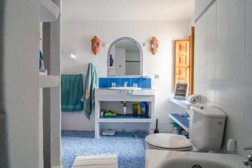 een badkamer met een wastafel, een toilet en een spiegel bij Beach and Mountains in Frigiliana