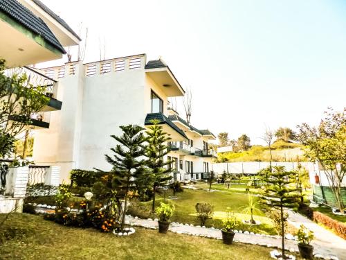 a building with trees and plants in a yard at Van Durga Villas & Suites in Padmi