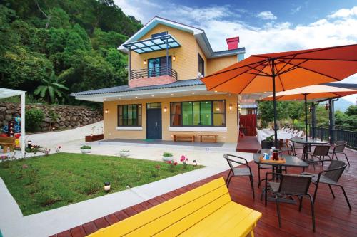 a house with a deck with a table and an umbrella at Sunlight Forest in Dahu