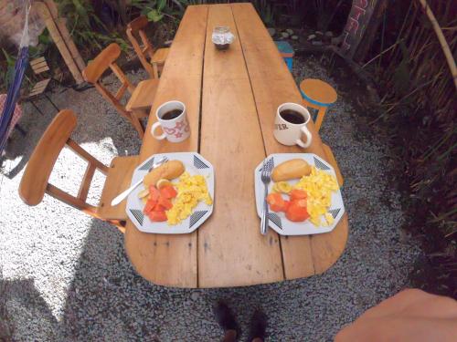 una mesa de picnic de madera con dos platos de comida. en Hostal Colina de Lluvia en Filandia