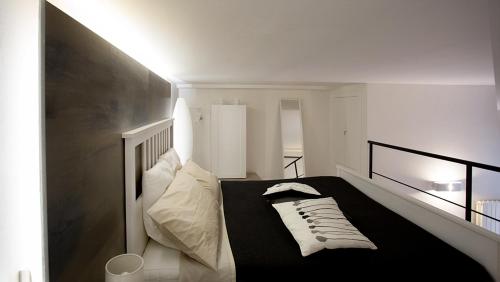 a bedroom with a black bed with white pillows at SpAsimoH-2 in Palermo