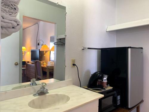 a bathroom with a sink and a mirror at Economy Inn Kingman in Kingman