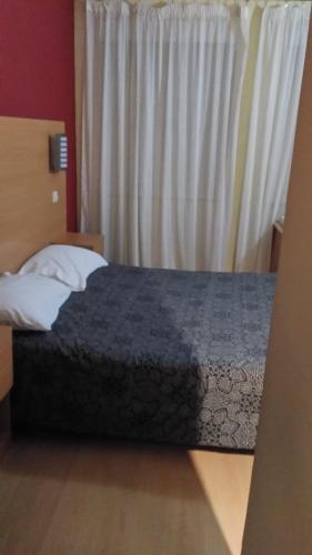 a bed in a hotel room with a window at Guest House Estrela in Porto