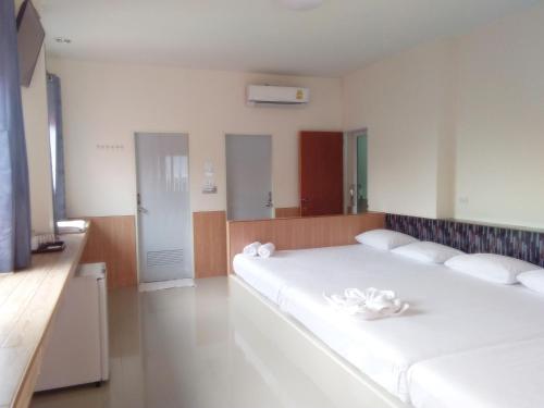 a bedroom with two beds with white towels on them at กู๊ดวิวสัตหีบ in Sattahip