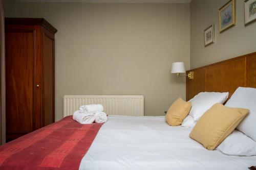 a bedroom with a large white bed with towels on it at Woolpack Inn in Eskdale