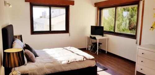 1 dormitorio con 1 cama y 2 ventanas en City Heart Rooms, en Oporto