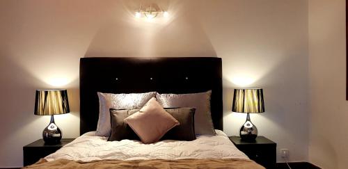 a bedroom with a large bed with two lamps at City Heart Rooms in Porto