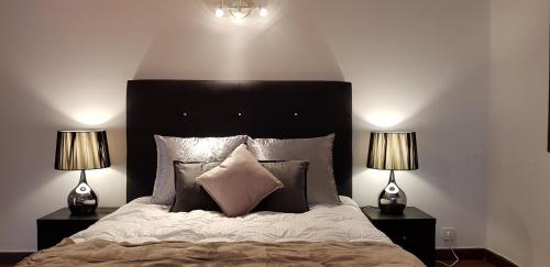 a bedroom with a large bed with two lamps at City Heart Rooms in Porto