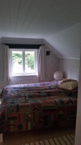 a bedroom with a bed and a window at Holsby banvaktarstuga in Ransäter
