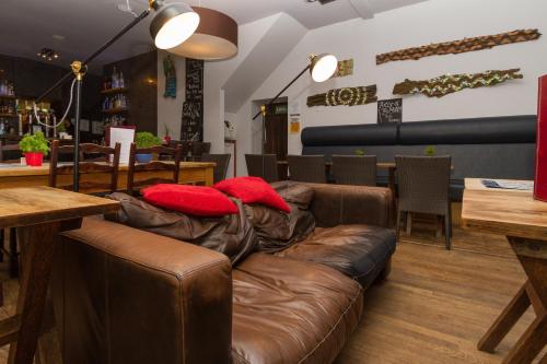 a brown couch with two red pillows on it at Woolpack Inn in Eskdale