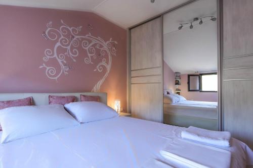 a bedroom with a large white bed and a mirror at Apartment Sea View in Kotor
