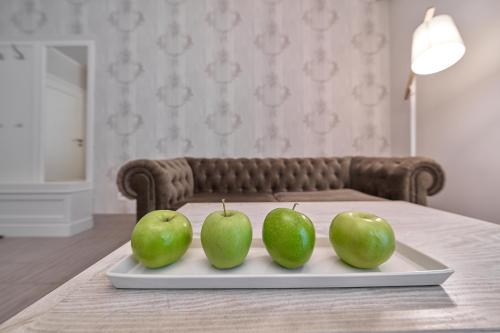 three green apples on a tray on a table at Górska Legenda Apartamenty & Domki in Szczyrk