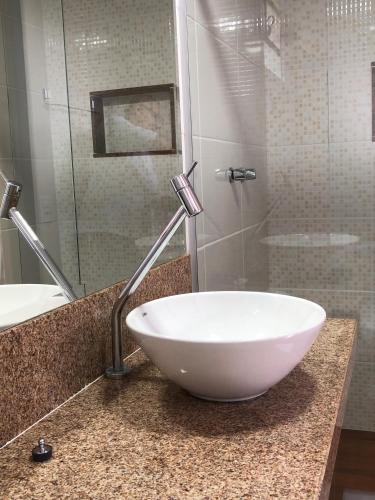 a bathroom with a white bowl sink on a counter at João e Maria Restaurante e Chalés in Tiradentes