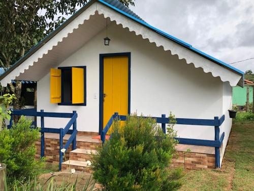 a small house with a yellow door at João e Maria Restaurante e Chalés in Tiradentes