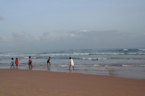 a group of people walking on the beach at Auberge Keur Diame in Dakar