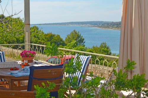a table and chairs with a view of the ocean at Casa Baia Tramonto in Patù