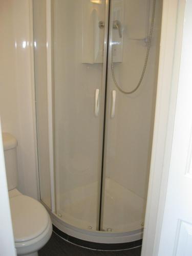 a bathroom with a shower and a toilet at Channel View Guest House in Weymouth