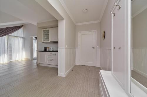 a kitchen with white walls and a wooden floor at Górska Legenda Apartamenty & Domki in Szczyrk