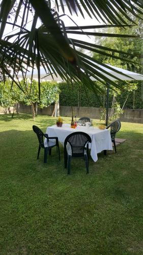 a table with a white tablecloth and chairs in the grass at Casa del Vigneto - NEW near VENICE - rooms+bathroom - INDEPENDENT in Spinea