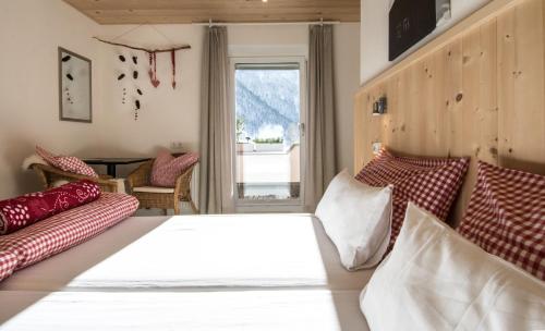 a bedroom with a bed and couches and a window at Lodge Seppaler - Sommerkarte Premium inklusive in Sankt Anton am Arlberg