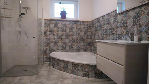 ein Bad mit einer Badewanne, einem Waschbecken und einer Dusche in der Unterkunft Ferienwohnung im Hinterhaus in Halle an der Saale