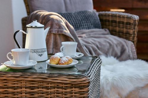 a table with two cups of coffee and pastries on it at Górska Legenda Apartamenty & Domki in Szczyrk